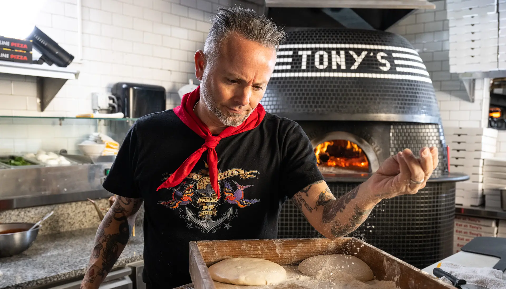 Tony Gemignani pulling a pizza from a wood-fired oven at Tony's Pizza Napoletana