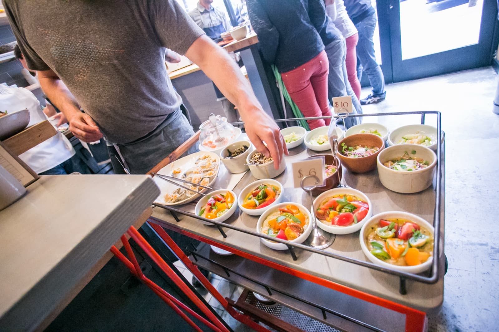 A server offering small plates from a roving tray in the dining room