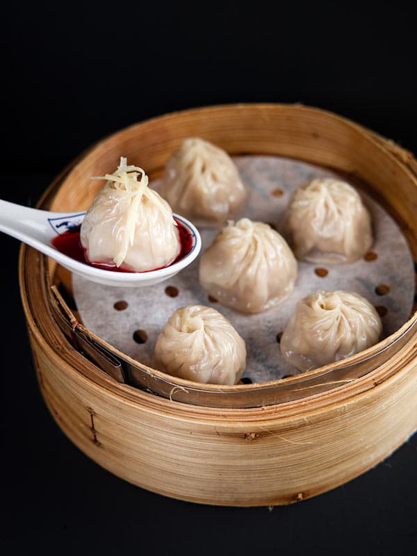 Shanghai Kurobuta pork soup dumplings in a bamboo steamer